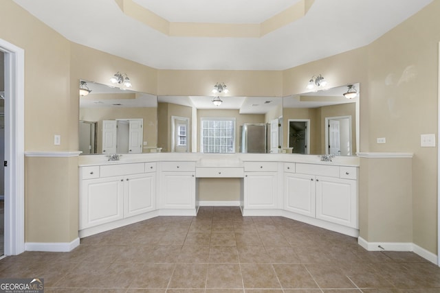 bathroom featuring tile patterned flooring, vanity, a tray ceiling, and walk in shower