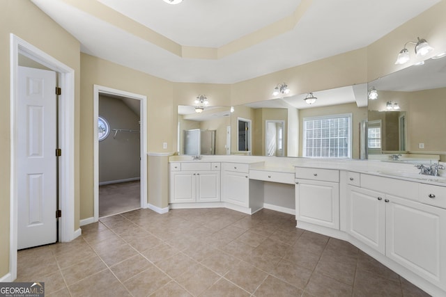 bathroom with tile patterned floors, a raised ceiling, and vanity