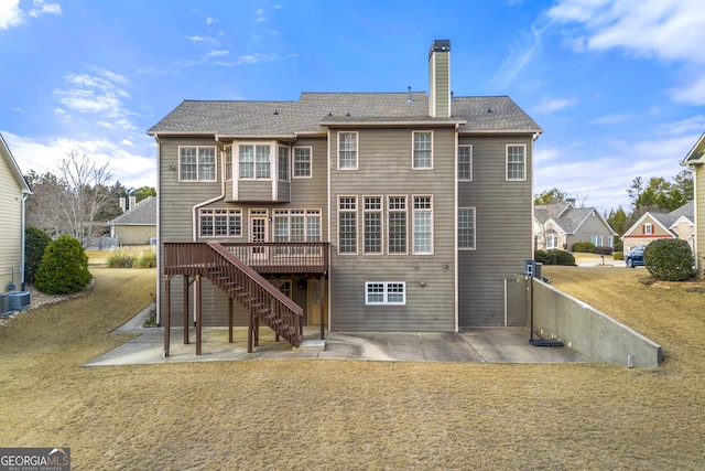 rear view of house featuring a wooden deck, a yard, a patio area, and central air condition unit