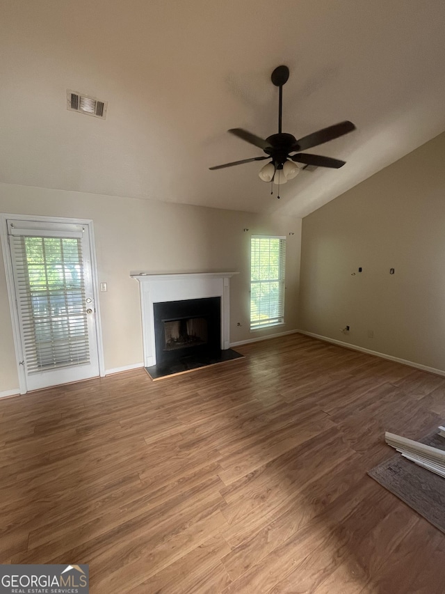 unfurnished living room featuring a ceiling fan, a fireplace, visible vents, and light wood-style floors