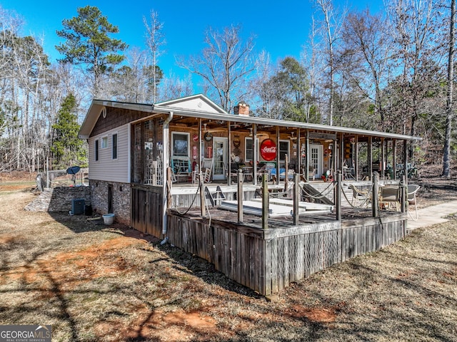 exterior space featuring central AC unit and a chimney