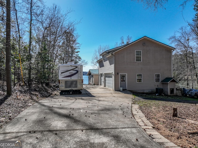 exterior space featuring a garage, driveway, and central AC unit