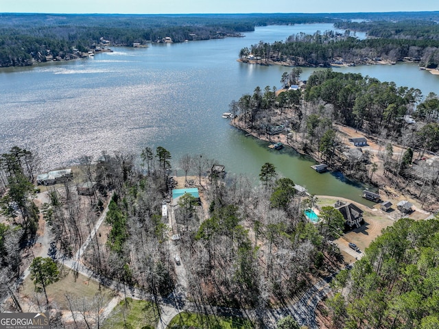 drone / aerial view featuring a water view and a wooded view