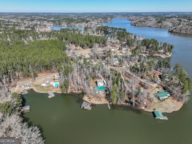 aerial view with a water view and a wooded view