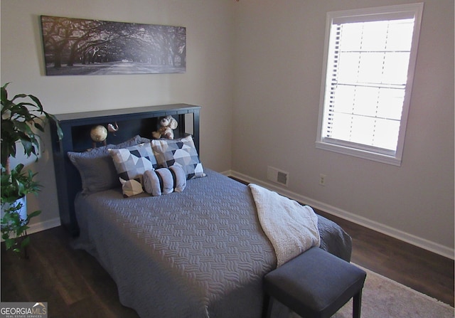 bedroom with dark hardwood / wood-style flooring