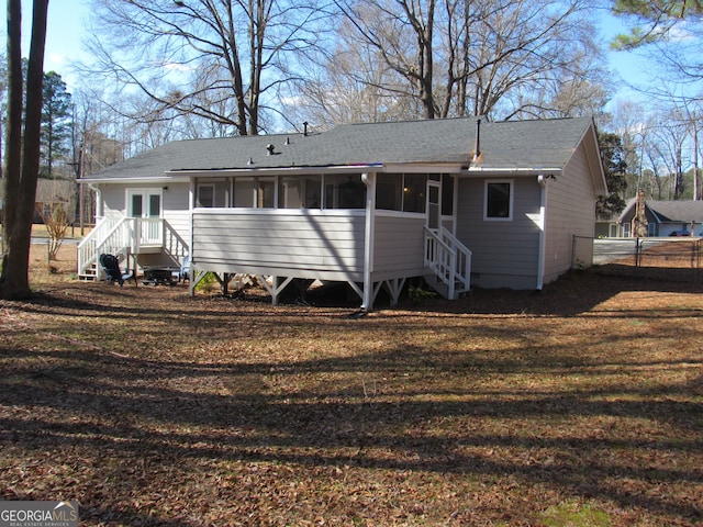 rear view of house featuring a sunroom