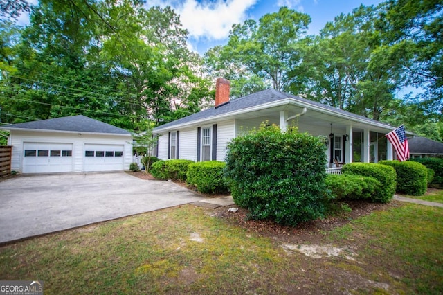 view of side of property with a garage, an outdoor structure, a porch, and a yard