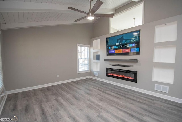 unfurnished living room featuring ceiling fan, wood-type flooring, and lofted ceiling with beams