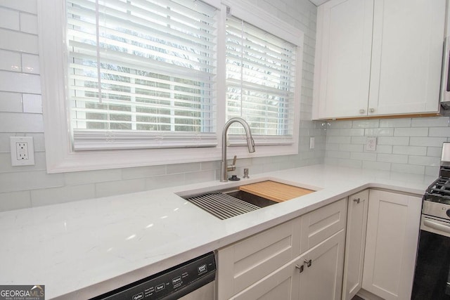 kitchen with sink, decorative backsplash, stainless steel appliances, and white cabinets