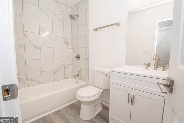 full bathroom featuring hardwood / wood-style flooring, vanity, toilet, and tiled shower / bath