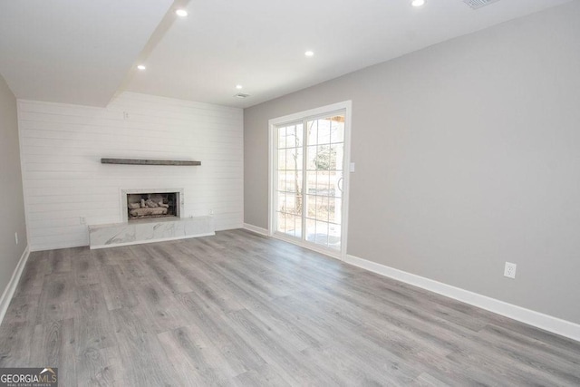 unfurnished living room with a fireplace and light wood-type flooring