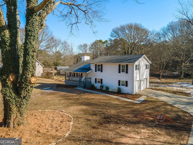 back of house featuring a garage and a lawn