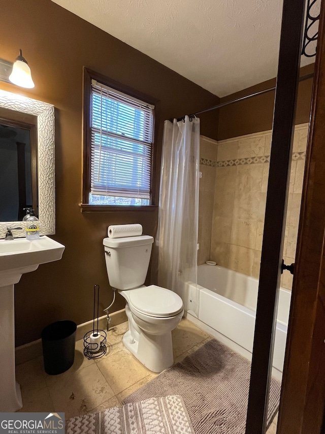 bathroom with a textured ceiling, shower / tub combo, tile patterned floors, and toilet