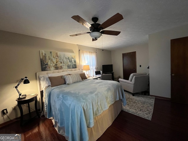 bedroom with dark wood-type flooring, ceiling fan, and a textured ceiling