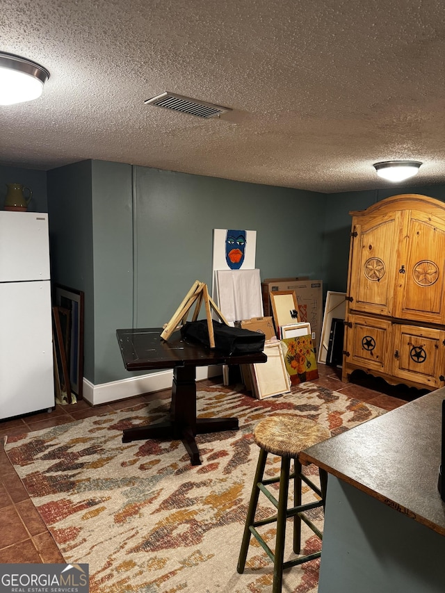 interior space with dark tile patterned floors and a textured ceiling