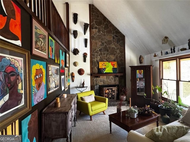 living area featuring carpet floors, a stone fireplace, and vaulted ceiling