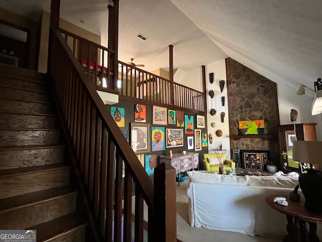 living room featuring lofted ceiling, a fireplace, and ceiling fan