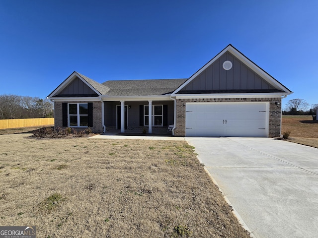 view of front of home with a garage, a front yard, and covered porch