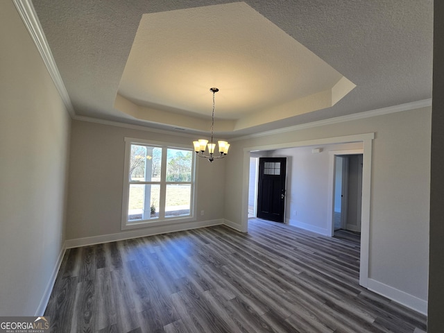 spare room featuring a raised ceiling, dark hardwood / wood-style floors, an inviting chandelier, and a textured ceiling