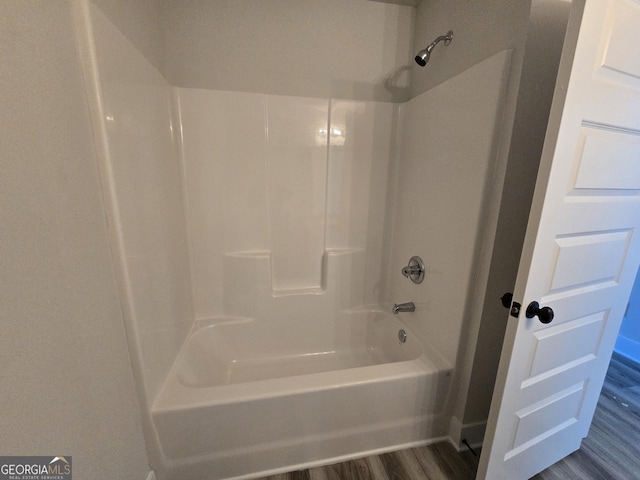 bathroom featuring hardwood / wood-style flooring and shower / washtub combination