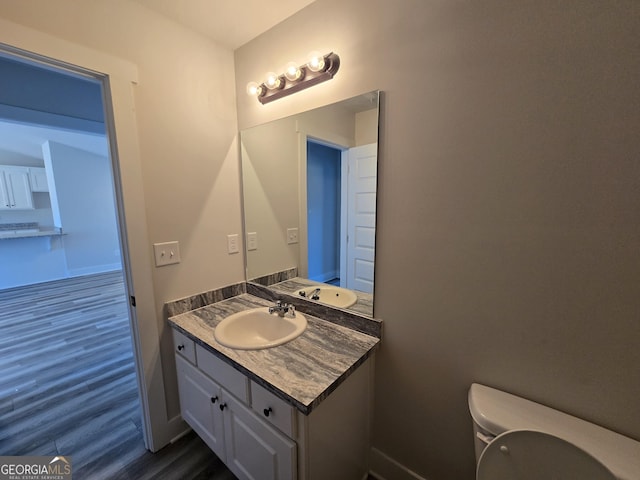 bathroom featuring vanity, wood-type flooring, and toilet