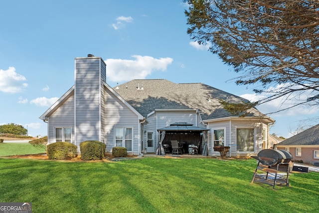 rear view of property with a gazebo and a lawn