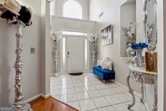 foyer featuring a towering ceiling and light tile patterned floors