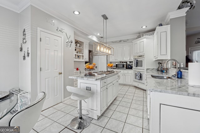 kitchen featuring sink, white cabinetry, stainless steel appliances, a center island, and light stone countertops