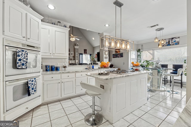 kitchen with white cabinetry, decorative light fixtures, kitchen peninsula, and double oven