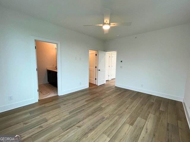 unfurnished bedroom featuring hardwood / wood-style flooring, ceiling fan, and ensuite bathroom