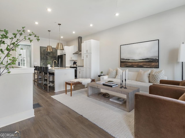 living room with dark wood-type flooring and sink