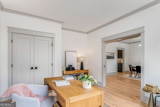 office area with ornamental molding and light hardwood / wood-style flooring