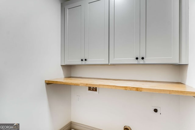 clothes washing area featuring cabinets and hookup for an electric dryer