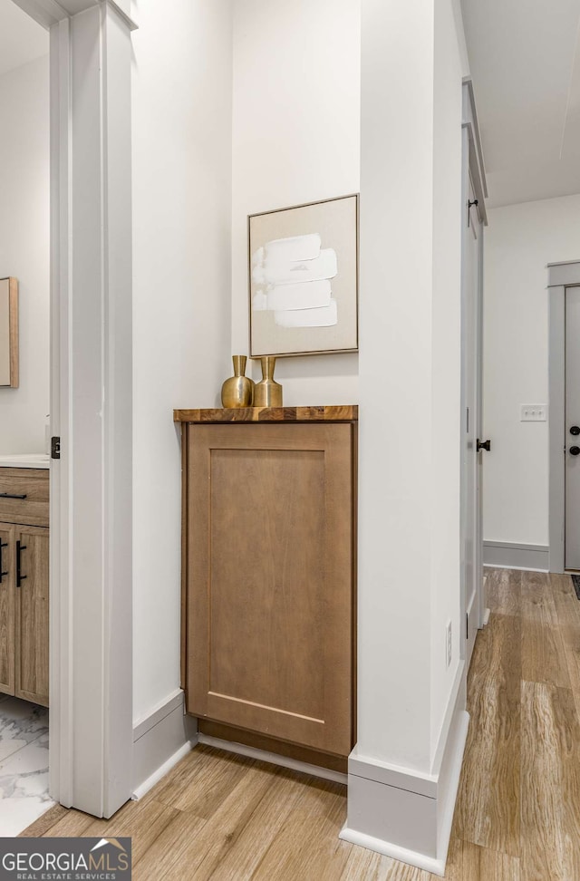 hallway featuring a barn door and light hardwood / wood-style flooring