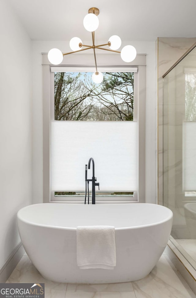 bathroom with an inviting chandelier and shower with separate bathtub