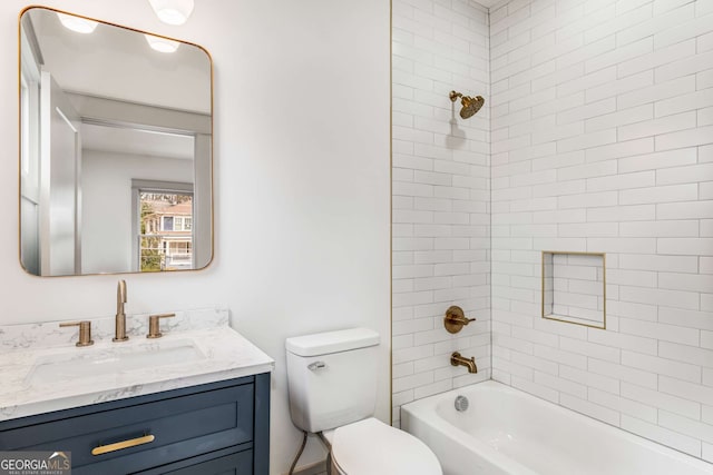 full bathroom featuring tiled shower / bath, vanity, and toilet