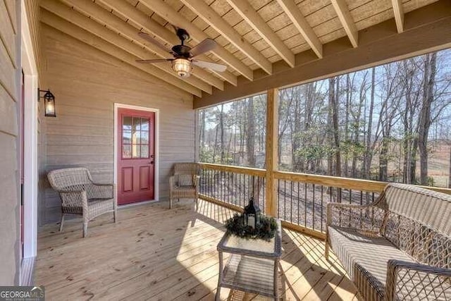 sunroom with vaulted ceiling with beams, wood ceiling, and ceiling fan