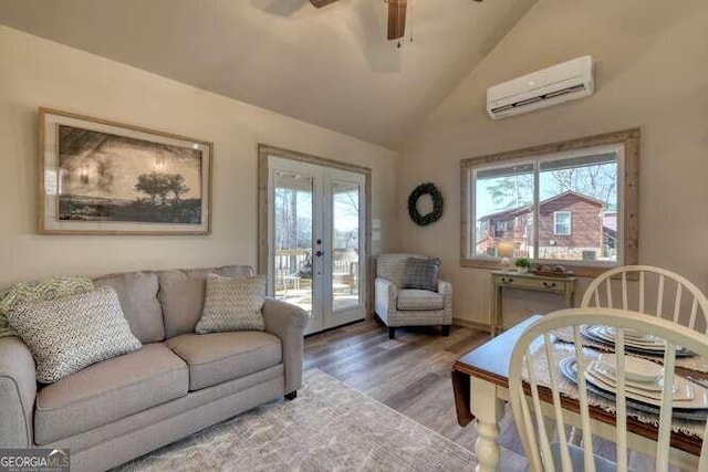 living room featuring ceiling fan, hardwood / wood-style floors, a wall mounted AC, vaulted ceiling, and french doors