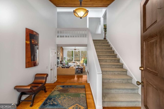 entrance foyer with hardwood / wood-style floors and a towering ceiling