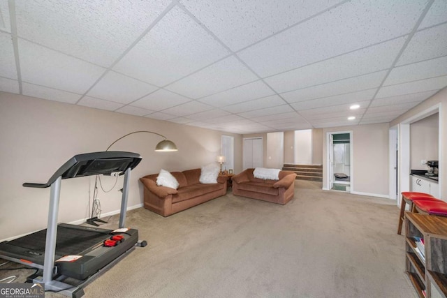 workout room featuring a paneled ceiling and light carpet