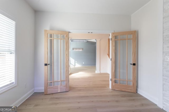 corridor featuring baseboards and wood finished floors