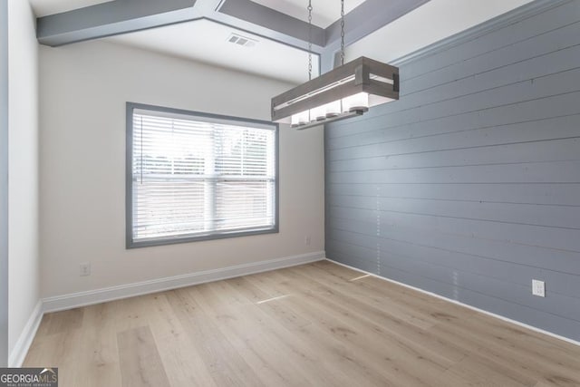 unfurnished dining area featuring a chandelier, visible vents, baseboards, and wood finished floors