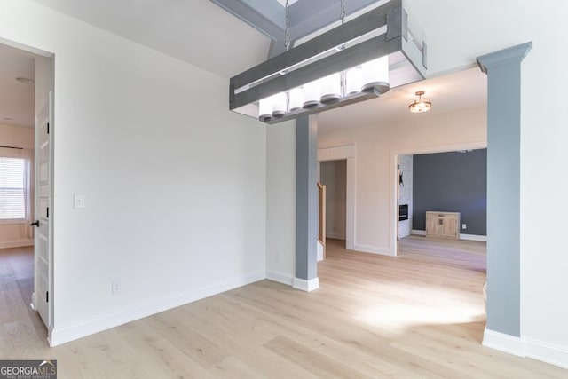 unfurnished room with baseboards and light wood-style floors