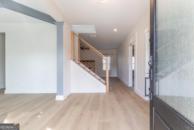 foyer with baseboards, stairway, visible vents, and light wood-style floors