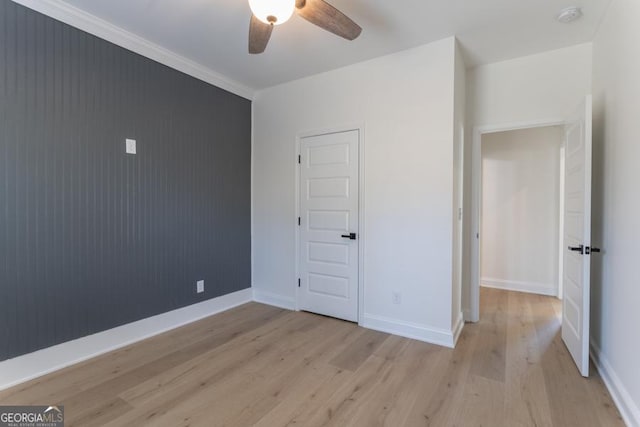 unfurnished bedroom featuring a ceiling fan, light wood-style flooring, and baseboards