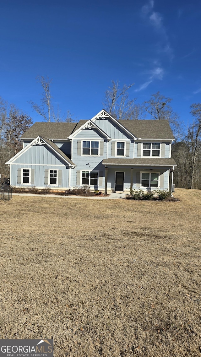 back of property featuring a lawn and board and batten siding