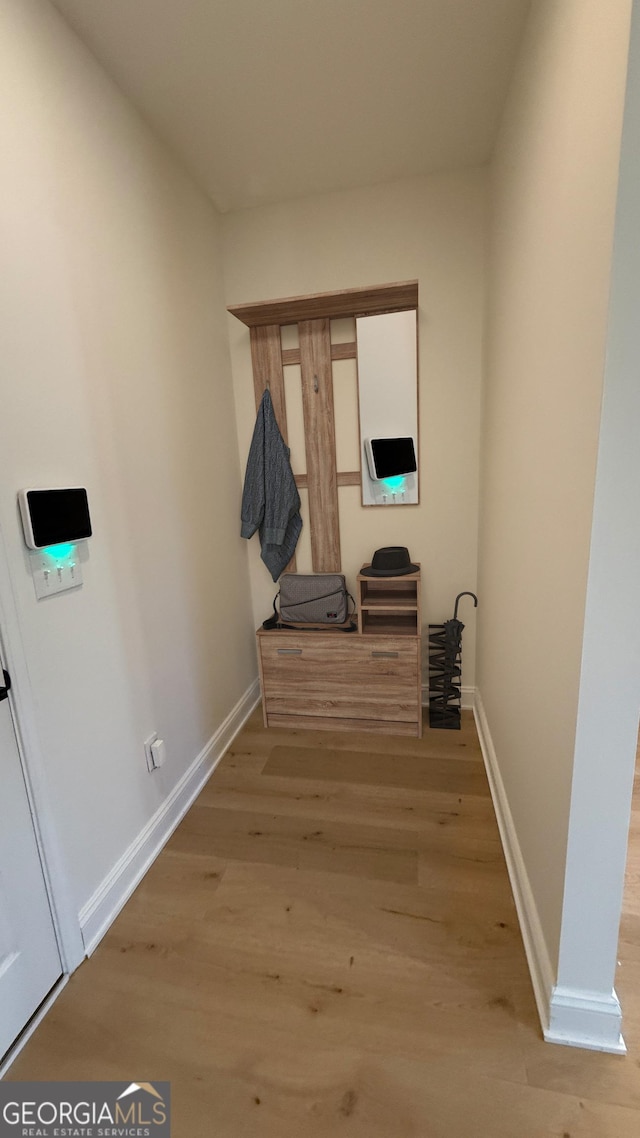 hallway with wood finished floors and baseboards