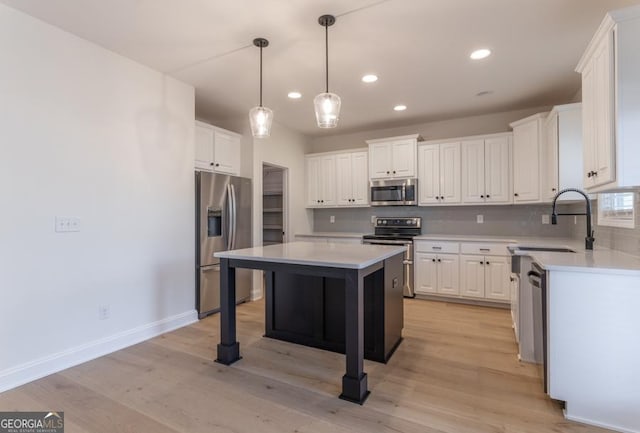 kitchen featuring a center island, tasteful backsplash, appliances with stainless steel finishes, white cabinetry, and a sink