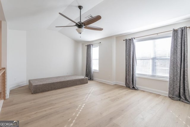 unfurnished bedroom featuring lofted ceiling, ceiling fan, baseboards, and wood finished floors