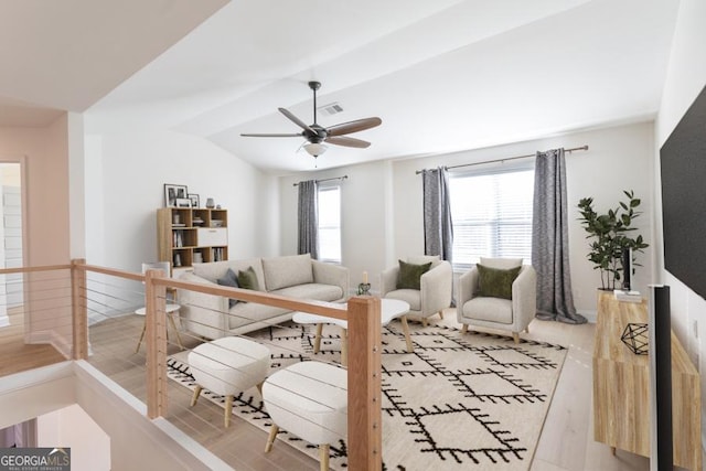 living area with light wood-style floors, ceiling fan, vaulted ceiling, and a wealth of natural light